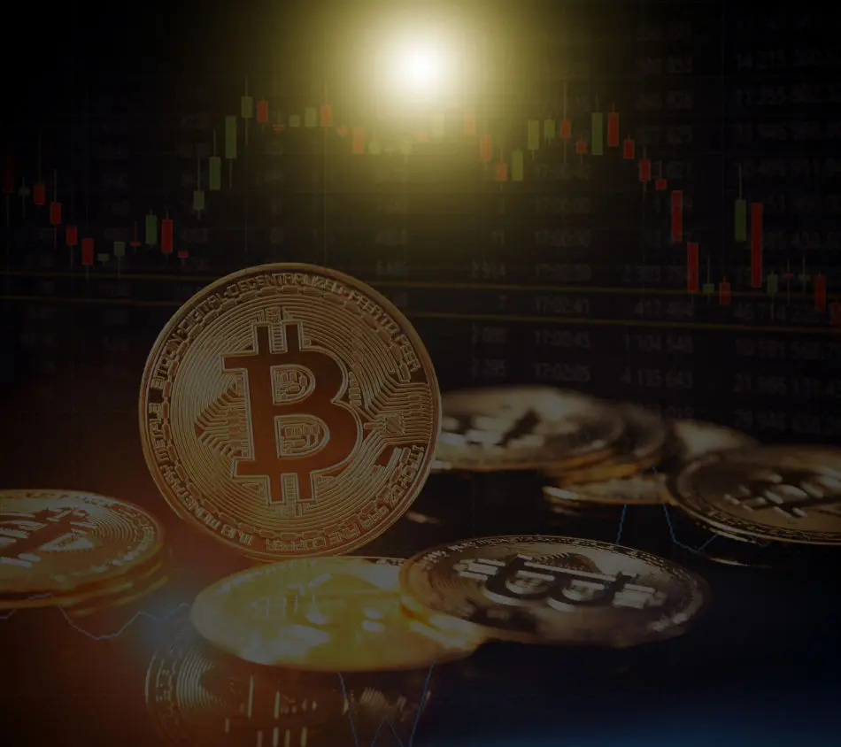 Stacks of gold coins engraved with the bitcoin logo as well as trading chart with candlesticks in the background